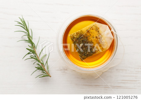 Cup of hot tea blended from rooibos, spearmint, apple, baobab on white wooden table. Cup of hot tea blended from rooibos, spearmint, apple, baobab on white wooden table. 121005276