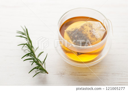 Cup of hot tea blended from rooibos, spearmint, apple, baobab on white wooden table. 121005277