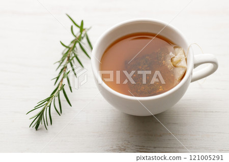 Cup of hot tea blended from rooibos, spearmint, apple, baobab on white wooden table. 121005291