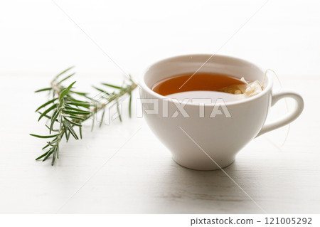 Cup of hot tea blended from rooibos, spearmint, apple, baobab on white wooden table. 121005292