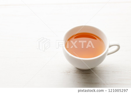 Cup of hot tea blended from rooibos, spearmint, apple, baobab on white wooden table. 121005297