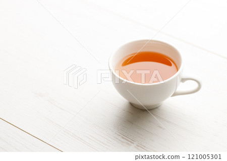 Cup of hot tea blended from rooibos, spearmint, apple, baobab on white wooden table. Cup of hot tea blended from rooibos, spearmint, apple, baobab on white wooden table. 121005301