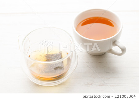 Cup of hot tea blended from rooibos, spearmint, apple, baobab on white wooden table. 121005304
