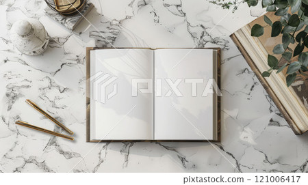 An open book with white pages on a marble surface, with stationery elements nearby 121006417
