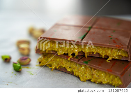 Trend Dubai chocolate with pistachio paste and kataifi dough. Confectionery handmade sweets at home in the kitchen. Trend Dubai chocolate with pistachio paste and kataifi dough. Confectionery handmade sweets at home in the kitchen. 121007435