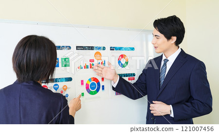A group of business people discussing while looking at a graph of business data 121007456