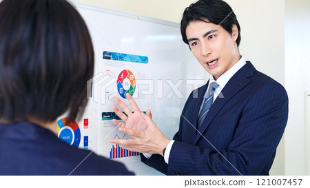 A group of business people discussing while looking at a graph of business data 121007457