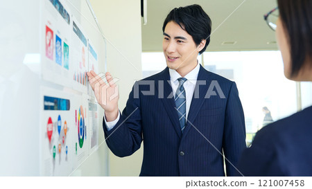 A group of business people discussing while looking at a graph of business data 121007458