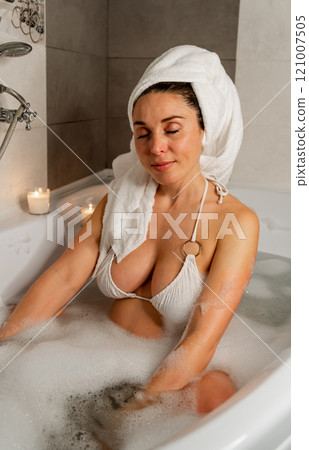 Pregnant woman with towel wrap in bubble bath Pregnant woman with towel wrap in bubble bath 121007505