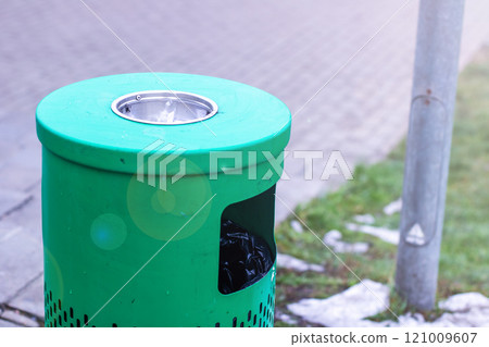 An ashtray that is completely filled with used cigarettes and a piece of paper 121009607