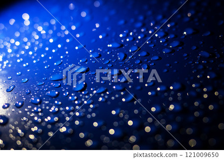 A vibrant blue background adorned with an abundance of water drops 121009650