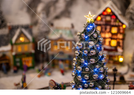 A Christmas tree with a star on top, in a snowy village 121009664