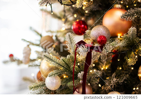 A vibrant red disco ball is beautifully hanging from a christmas tree A vibrant red disco ball is beautifully hanging from a christmas tree 121009665