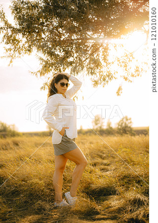 Young beautiful woman with long hair. Summer day. Full length portrait in the park. 121010160