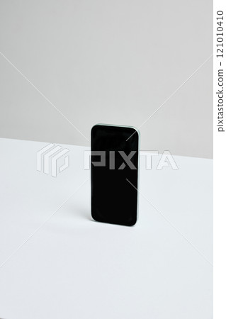 Smartphone in sleek vertical position on neutral desk. Ample negative space for overlays, branding, or showcasing app designs. Smartphone in sleek vertical position on neutral desk. Ample negative space for overlays, branding, or showcasing app designs. 121010410