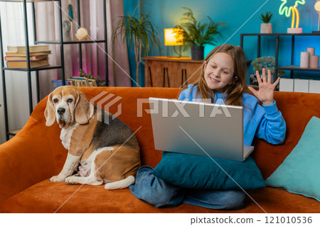 Happy preteen girl making video webcam conference call with friends or family enjoying conversation 121010536