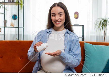 Pregnant young woman taking drug drinking water to nourish unborn child healthy pregnancy concept 121010543