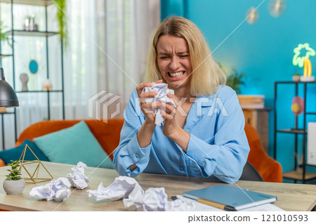 Angry furious woman working at home throwing crumpled paper having nervous breakdown failure at work Angry furious woman working at home throwing crumpled paper having nervous breakdown failure at work 121010593