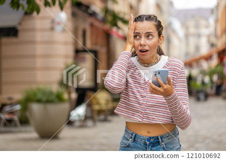 Woman using smartphone shock sudden lottery results bad news fortune loss app fail virus thief fraud 121010692