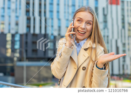 Mature Caucasian businesswoman having remote conversation on smartphone on downtown city street Mature Caucasian businesswoman having remote conversation on smartphone on downtown city street 121010766