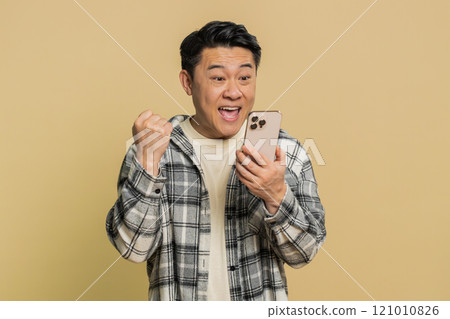 Happy excited winner man use smartphone celebrating success winning play game good lottery news Happy excited winner man use smartphone celebrating success winning play game good lottery news 121010826