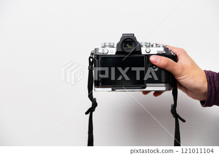 Hand holding retro camera with neck strap on white background. Vintage things, mixing old and modern style in camera design Hand holding retro camera with neck strap on white background. Vintage things, mixing old and modern style in camera design 121011104