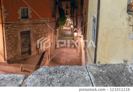 Old historic street illuminated at night in Girona, Spain 121011216