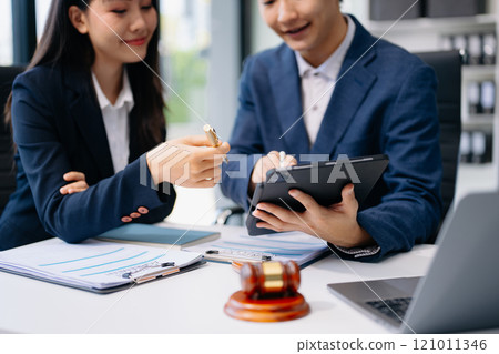 Business and lawyers discussing contract papers with brass scale on desk in office. Law, legal services, advice, justice and law Business and lawyers discussing contract papers with brass scale on desk in office. Law, legal services, advice, justice and law 121011346