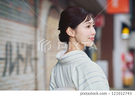 A woman walking through the city in a kimono 121012743