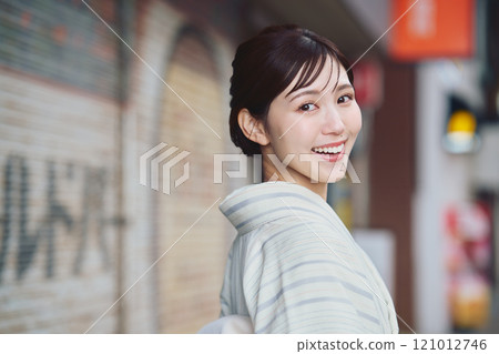 A woman walking through the city in a kimono A woman walking through the city in a kimono 121012746