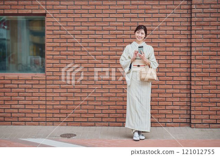 A woman walking through the city in a kimono 121012755