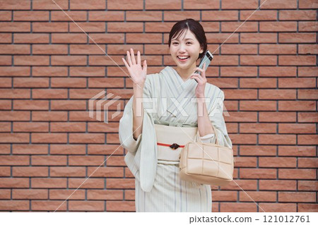 A woman walking through the city in a kimono A woman walking through the city in a kimono 121012761
