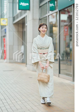 A woman walking through the city in a kimono 121012769