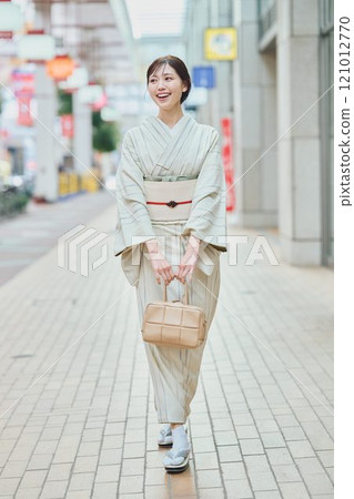 A woman walking through the city in a kimono 121012770