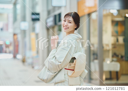 A woman walking through the city in a kimono 121012781