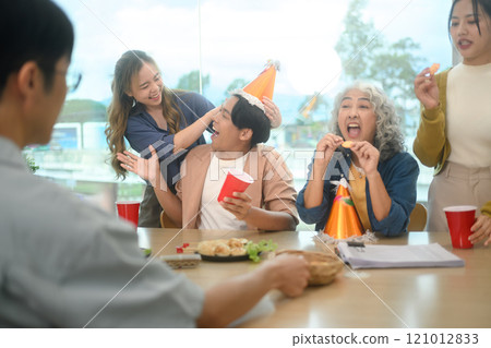 Group of cheerful coworkers enjoying at the office birthday party Group of cheerful coworkers enjoying at the office birthday party 121012833