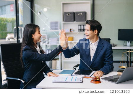 Judge and client shaking hands and lawyers discussing contract papers after adviced in background at courtroom, lawyer service 121013163