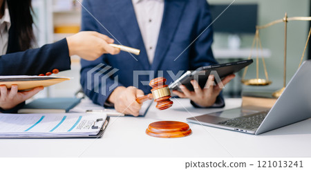 Two lawyers are discussing about contract paper, law matters determination, pointing.law and hammer Two lawyers are discussing about contract paper, law matters determination, pointing.law and hammer 121013241