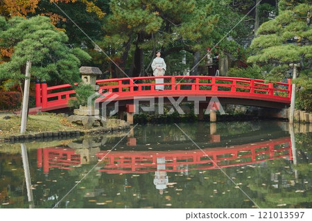 A woman in kimono standing on a bridge 121013597