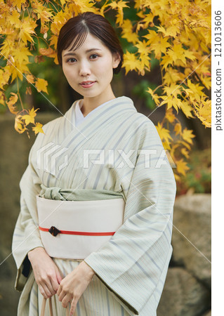 A woman wearing a kimono among autumn leaves A woman wearing a kimono among autumn leaves 121013606