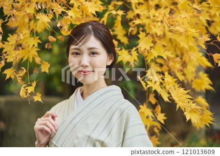 A woman wearing a kimono among autumn leaves 121013609