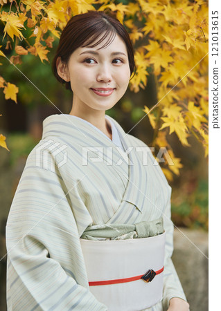 A woman wearing a kimono among autumn leaves A woman wearing a kimono among autumn leaves 121013615