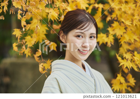 A woman wearing a kimono among autumn leaves A woman wearing a kimono among autumn leaves 121013621