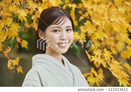 A woman wearing a kimono among autumn leaves 121013622