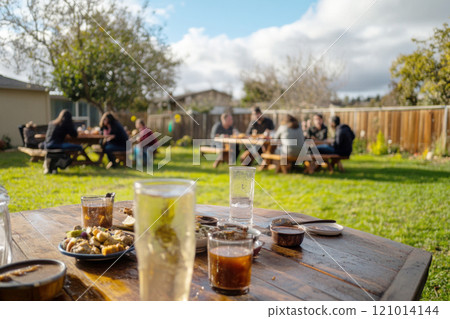 Family gathered for outdoor autumn feast with roasted turkey, enjoying food Family gathered for outdoor autumn feast with roasted turkey, enjoying food 121014144