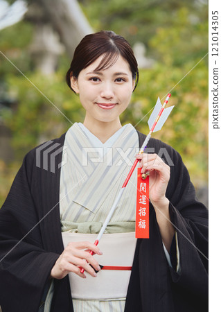 Woman holding a hamaya arrow Woman holding a hamaya arrow 121014305