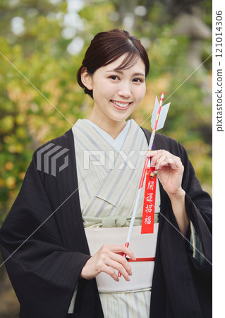 Woman holding a hamaya arrow Woman holding a hamaya arrow 121014306