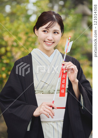 Woman holding a hamaya arrow Woman holding a hamaya arrow 121014308