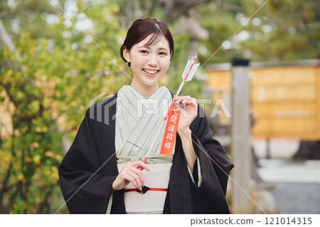 Woman holding a hamaya arrow 121014315