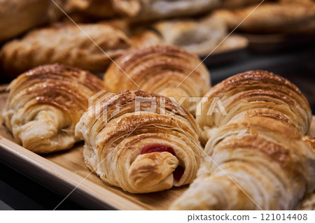 Fresh hot pastries in bakery, puff pastry croissants with raspberry 121014408